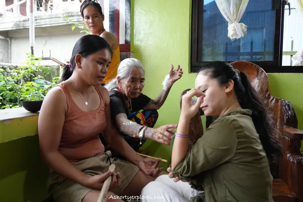 Apo Whang Od supervising tattoo process 